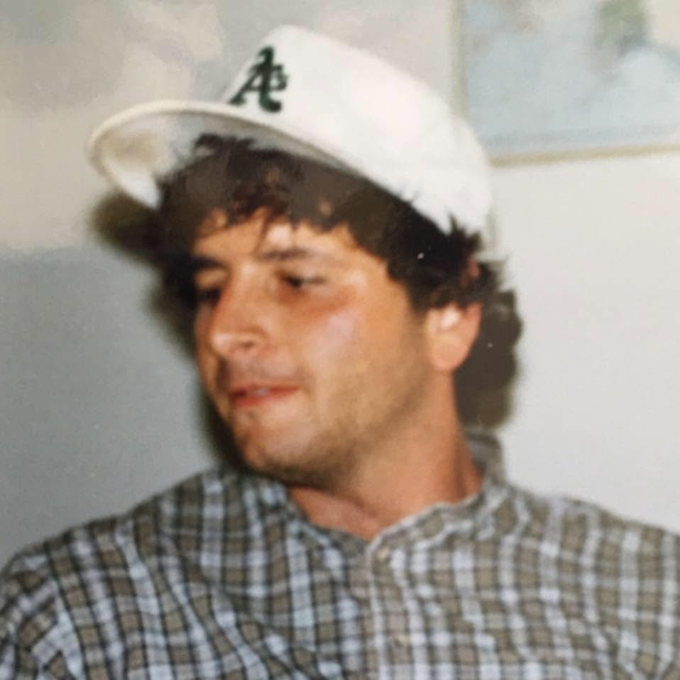 A vintage photograph of Steve wearing a baseball cap